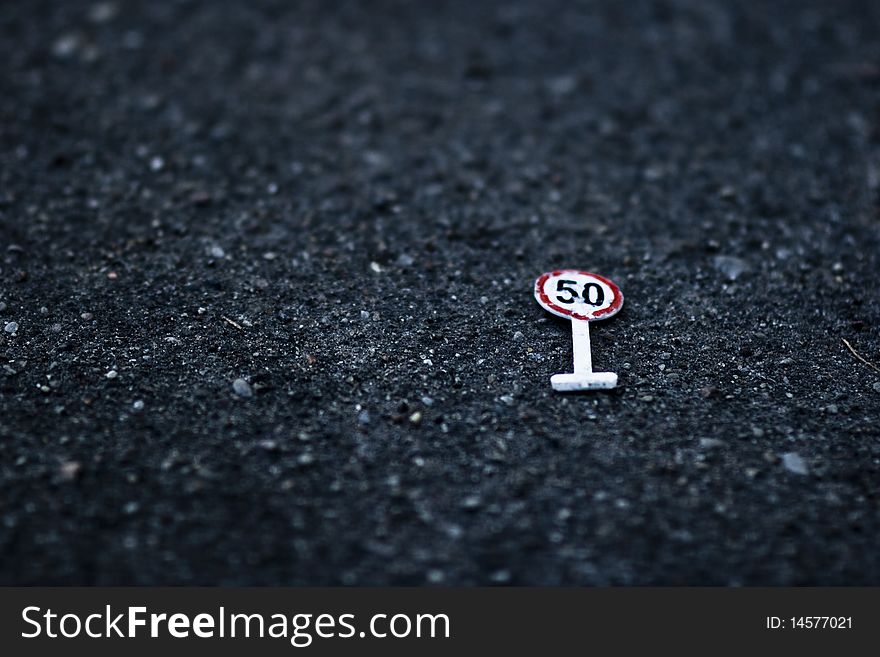 Speed limit sign made from toys and now lying ont the ground