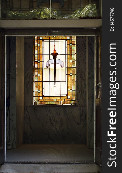 Entrance to the crypt with a stained glass window in the background