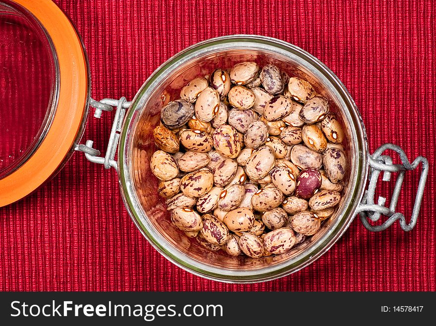 A glass preserving jar on a red fabric background. A glass preserving jar on a red fabric background.