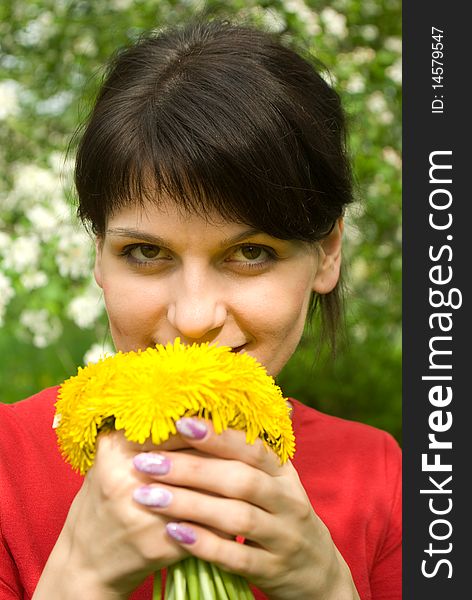 Beautiful smiling girl with bouquet of dandelions in a spring garden. Beautiful smiling girl with bouquet of dandelions in a spring garden