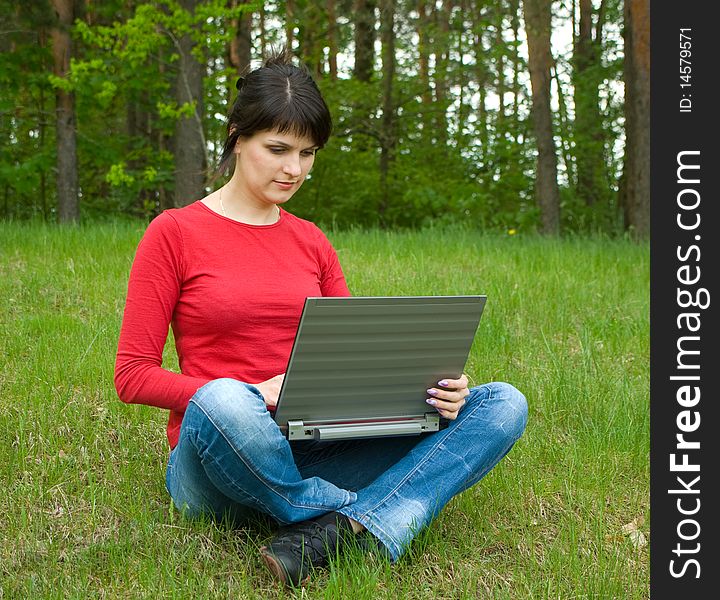 Beautiful girl with a laptop on forest glade. Beautiful girl with a laptop on forest glade