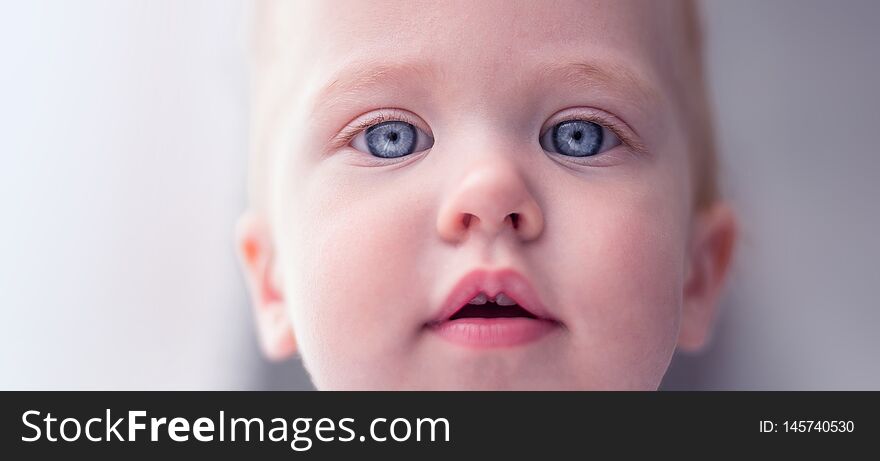 Wondering little girl posing. Attractive tiny. Funny babe. The child looks from top to bottom.