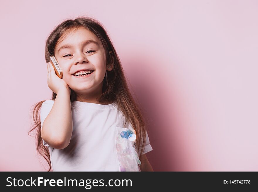 Cute Little Girl Talking On Phone On Pink Background