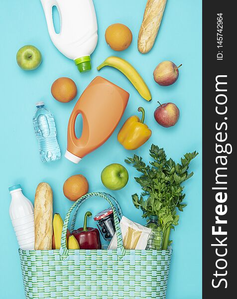 Fresh vegetables and grocery products falling into a reusable shopping bag. Fresh vegetables and grocery products falling into a reusable shopping bag