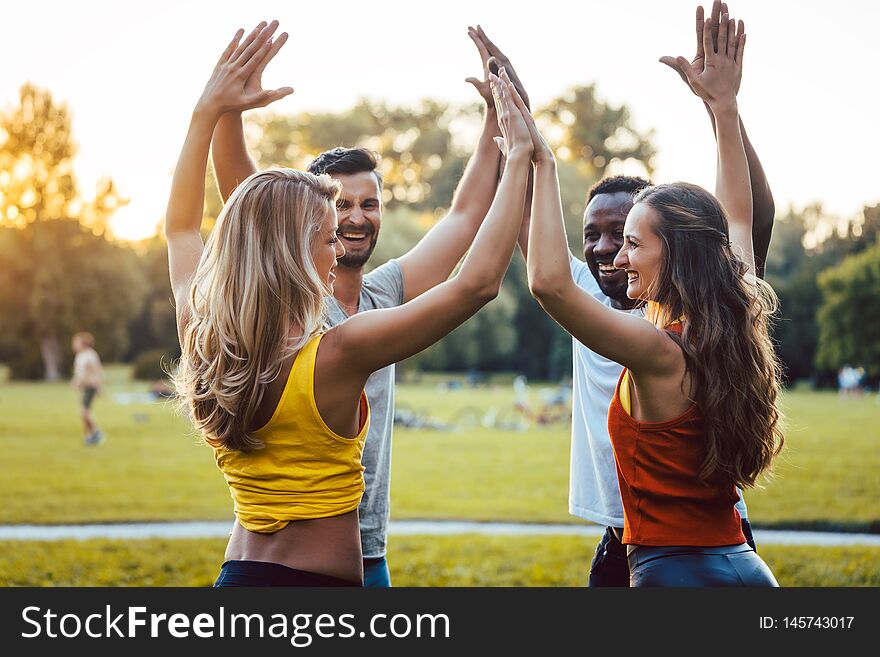 Friends having fun in the park enjoying themselves sticking close together