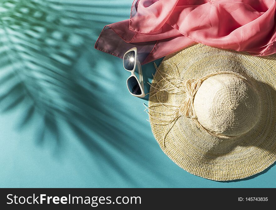 Summer beach vacations and tropical destinations: straw hat, sunglasses, scarf and palm leaves shadow, blank copy space