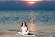 Young Girl Doing Yoga At Sunrise On Beach. Stock Images