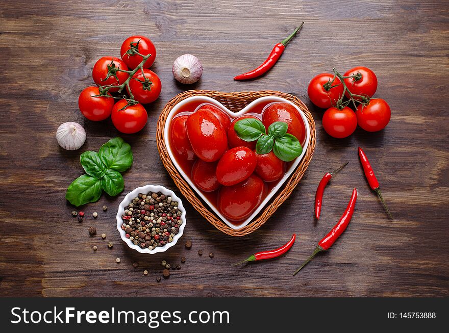 Whole canned tomatoes in their own juice with spices on a dark wooden background. Selective focus