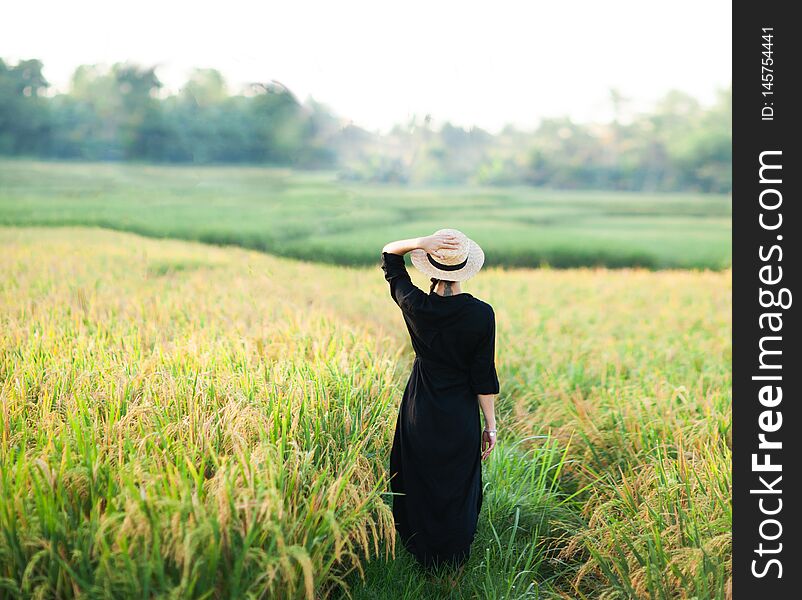 Woman in black dress and straw hat.