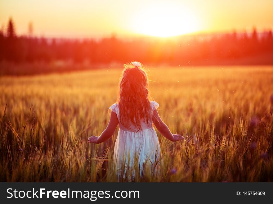 Little girl in white dress in field