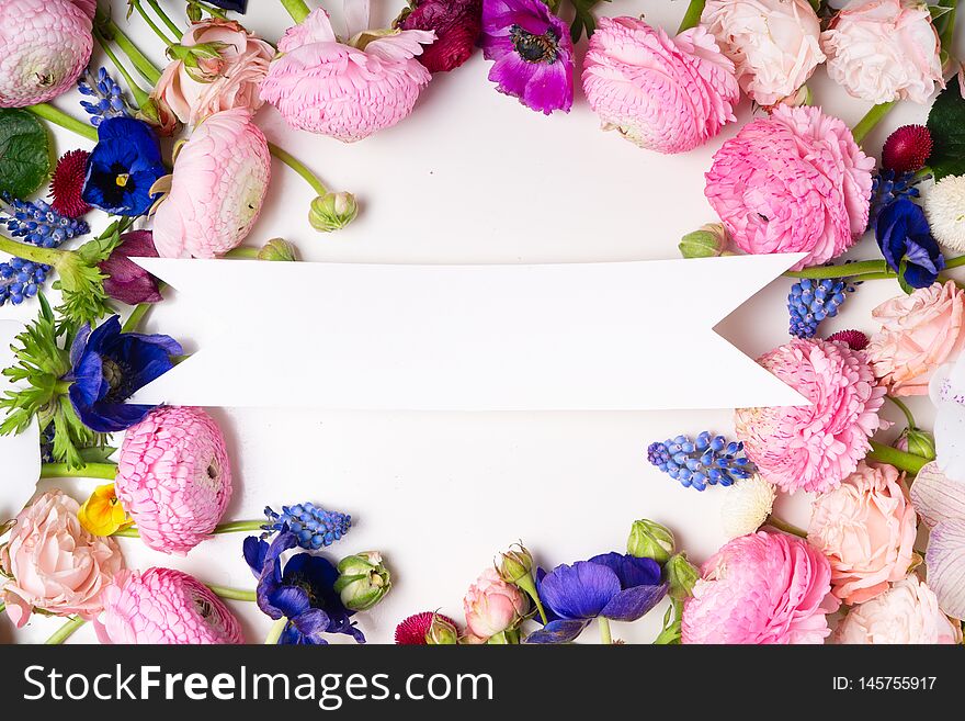 Flowers composition. Frame made of roses, ranunculus and orchids flowers on white background. Flat lay, top view scene. Flowers composition. Frame made of roses, ranunculus and orchids flowers on white background. Flat lay, top view scene.