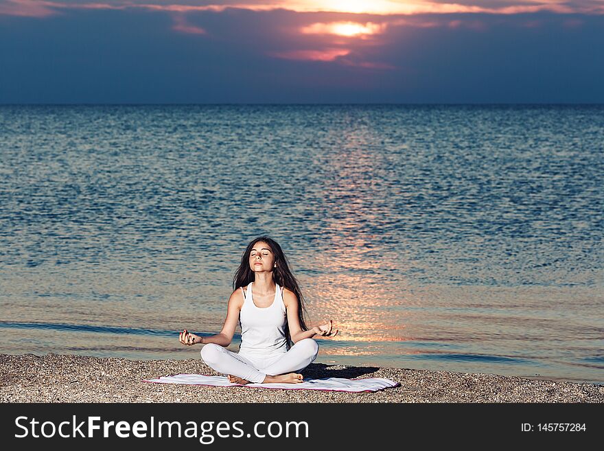 Young Girl Doing Yoga At Sunrise On Beach.