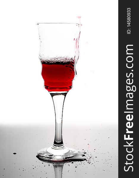 Red wine splashing in glass.