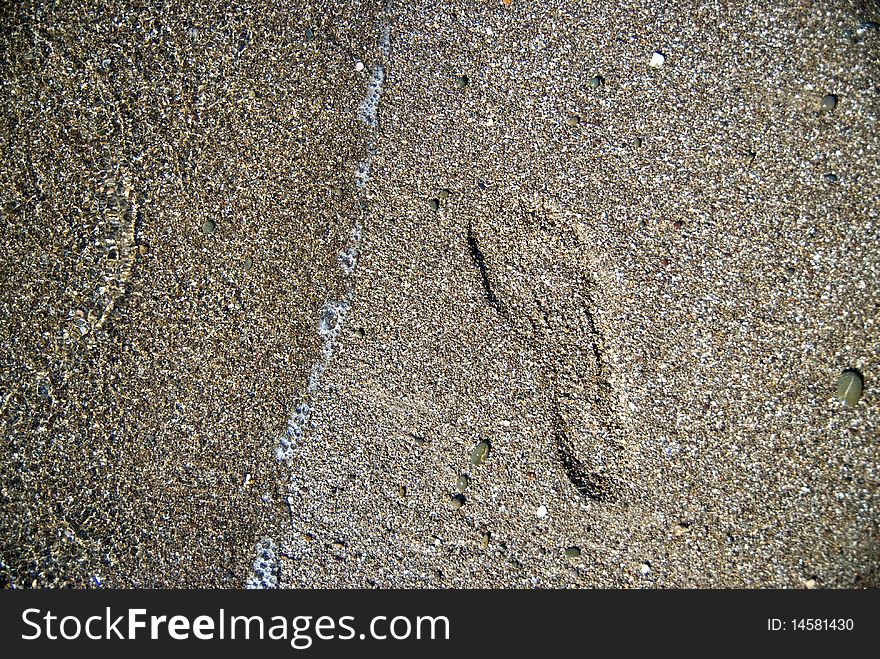 Sand stones with footprint and water wave