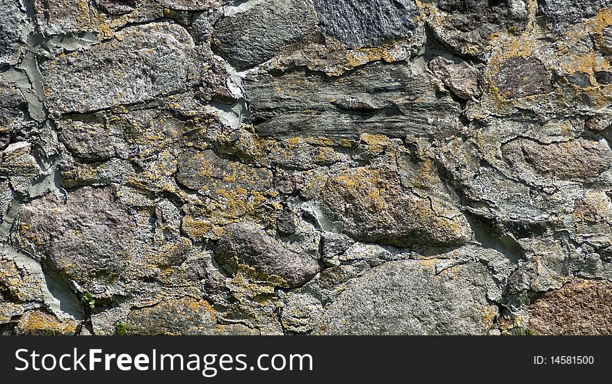 A stone wall overgrown with moss