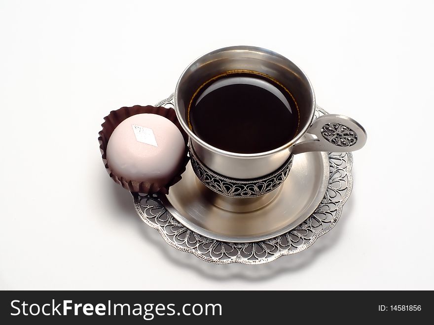 Silver cup of coffee with white cake is on the white background