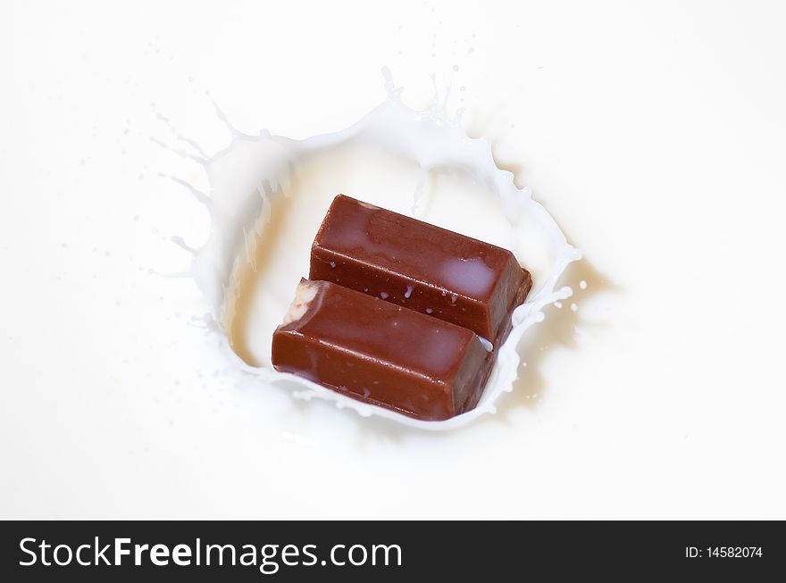 Chocolate candy splashing into white milk