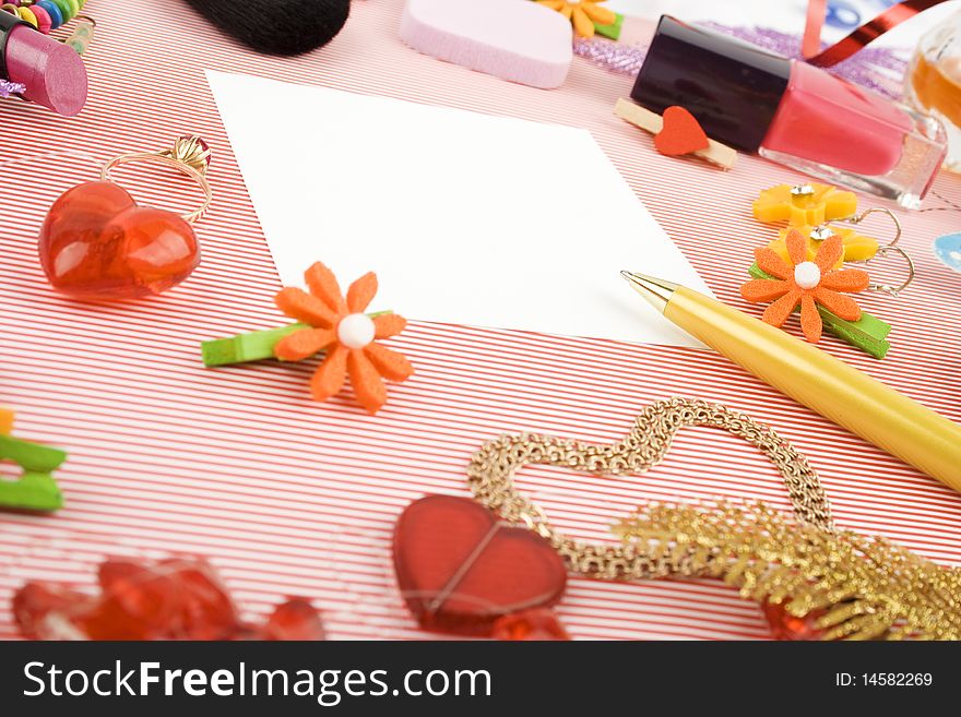 Background for Women's Day in pink. Lipstick, earrings, ring, red heart, nail polish, flowers, perfume, sparkles, white sheet of paper and pen gold. Background for Women's Day in pink. Lipstick, earrings, ring, red heart, nail polish, flowers, perfume, sparkles, white sheet of paper and pen gold