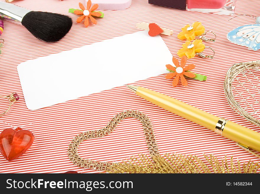 Background for Women's Day in pink. Lipstick, earrings, ring, red heart, nail polish, flowers, perfume, sparkles, white sheet of paper and pen gold. Background for Women's Day in pink. Lipstick, earrings, ring, red heart, nail polish, flowers, perfume, sparkles, white sheet of paper and pen gold