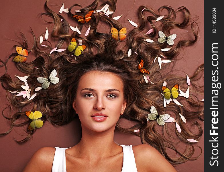 Beautiful woman with petals and butterflies in her hair. Beautiful woman with petals and butterflies in her hair