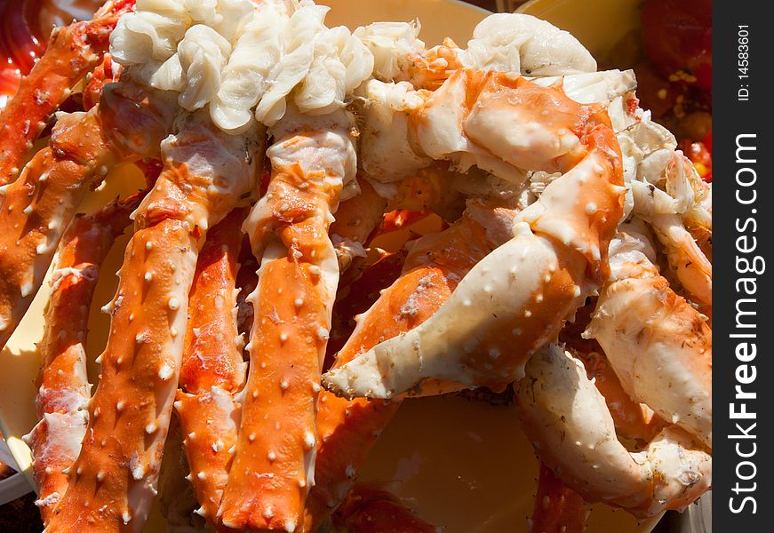 Boiled paws of the crab put on plate in the manner of background