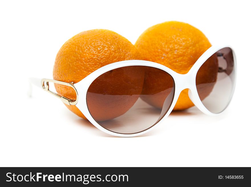 Sunglasses and two oranges on white background
