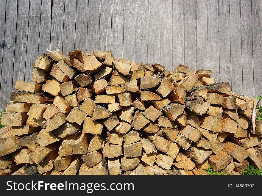 Freshly Cut Firewood in front of Grey Barn Wall