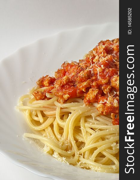 Spaghetti a la Bolognese in the white plate over grey gradient background