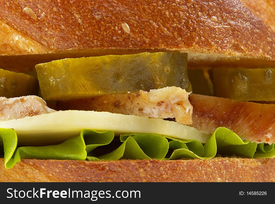 Sandwich with fried chicken and pickle cucumber macro shot background. Sandwich with fried chicken and pickle cucumber macro shot background