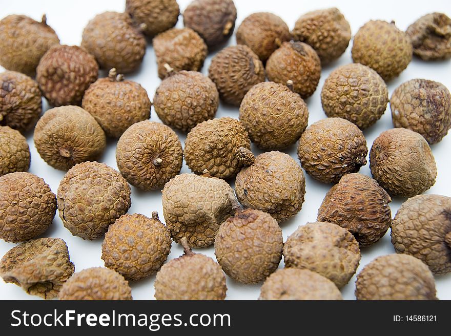 Many dried litchi on white