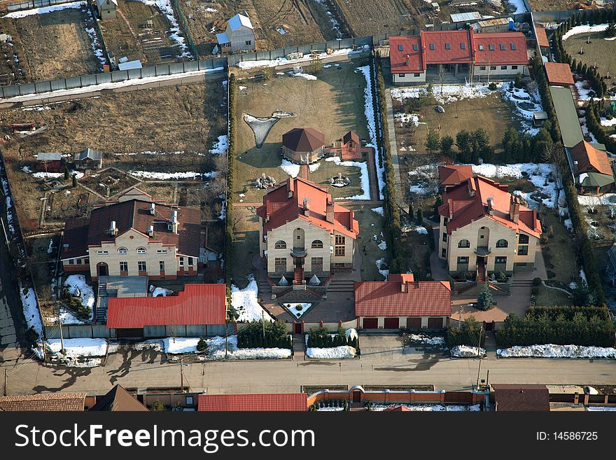 Three cottages with red and brown roofs from the sky