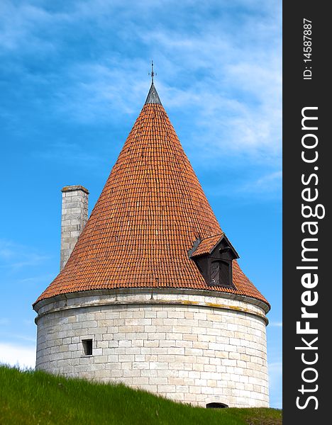 Kuressaare castle tower with blue sky in background and green grass in foreground (Saarema, Estonia)