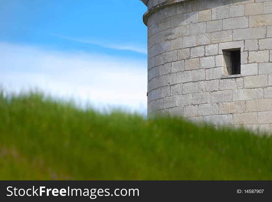 Kuressaare castle tower with blue sky in background and green grass in foreground (Saarema, Estonia)