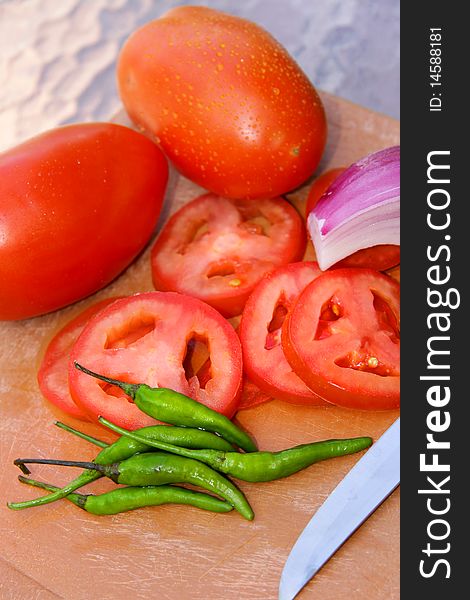 Cut Tomatoes , Onions and green chillies on cutting board. Cut Tomatoes , Onions and green chillies on cutting board