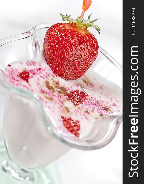 Milk shake with strawberries on white table top