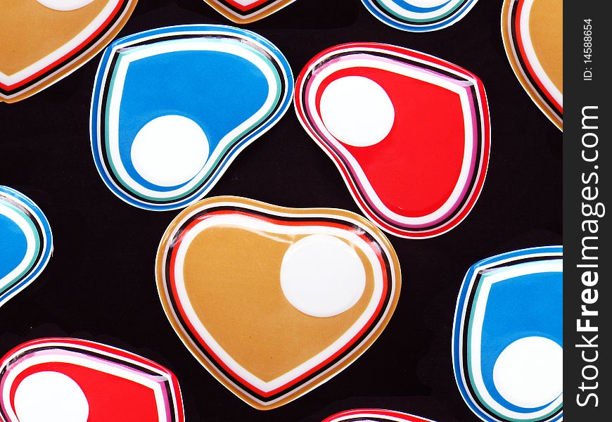 A background of colored heart shaped designer saucers. A background of colored heart shaped designer saucers