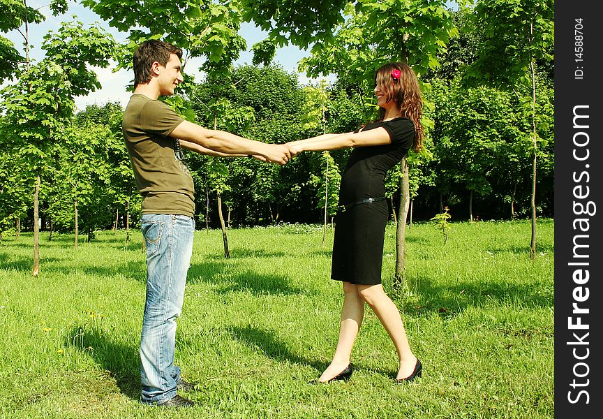 Young man and girl holding for hands outdoor summer time