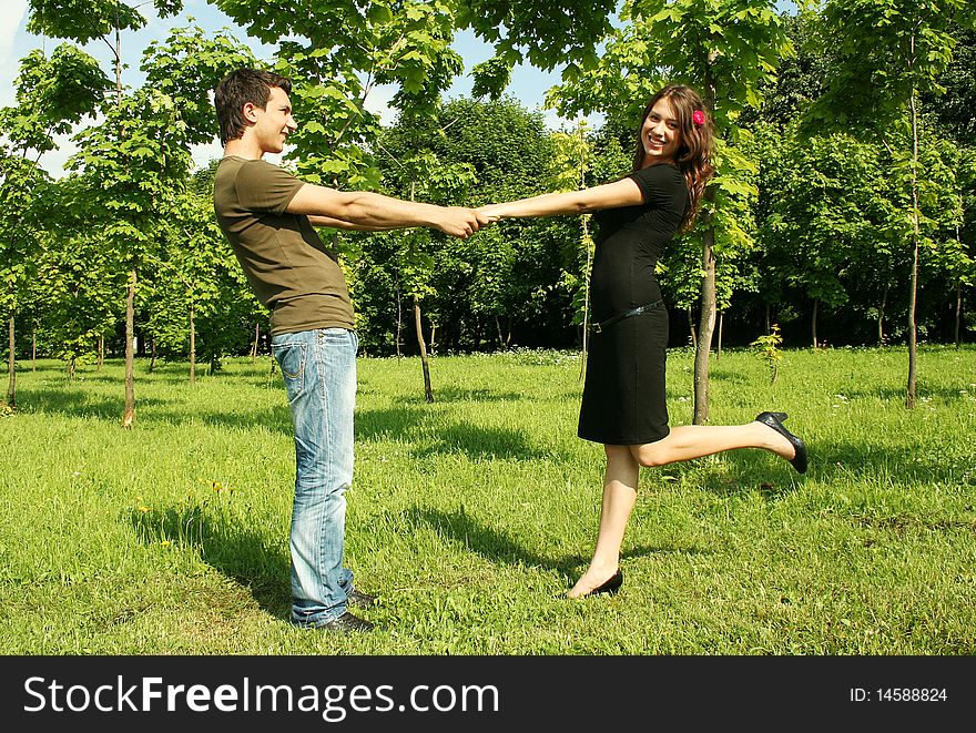 Young man and girl holding for hands outdoor summer time