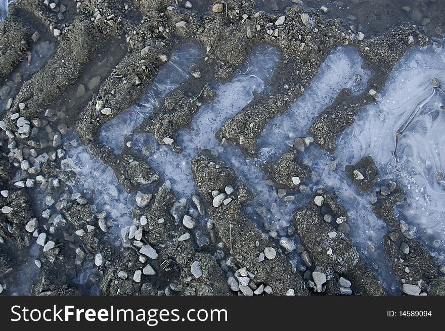 Frozen truck tracks in the mud. Road in the winter.