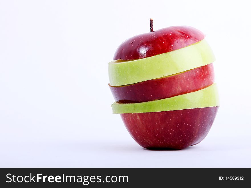 Red and green apple slices over white background. Space to insert text or design.