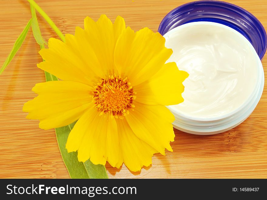 Hydrating cream and a yellow daisy