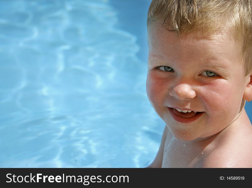 A 3-year old blue eyed boy at a swimming pool. A 3-year old blue eyed boy at a swimming pool