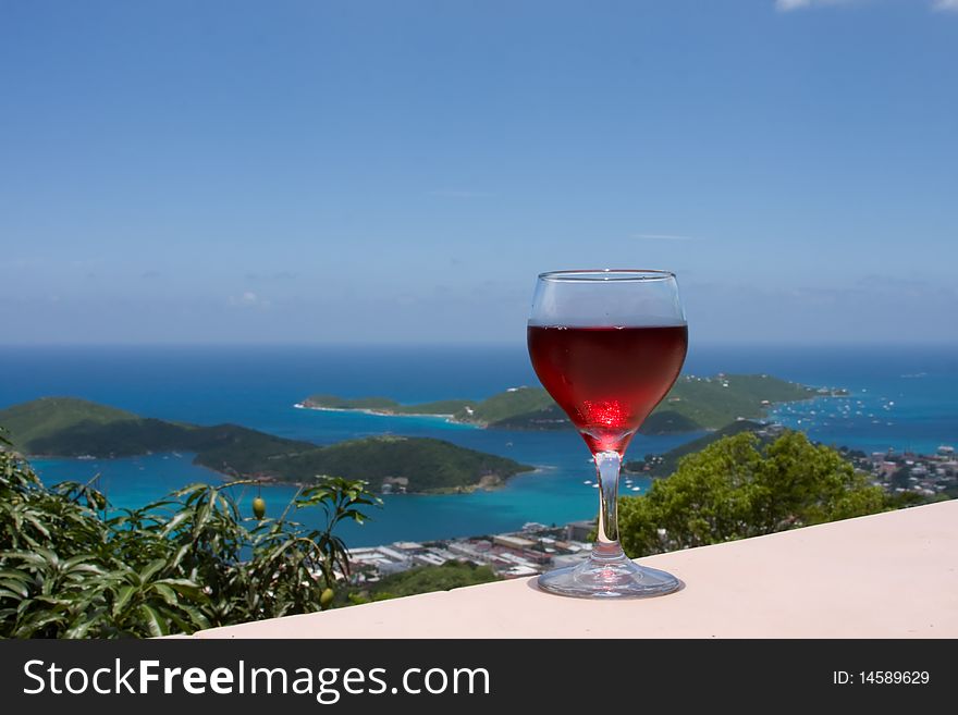 Red wine overlooking a caribbean island blue water and sky. Red wine overlooking a caribbean island blue water and sky