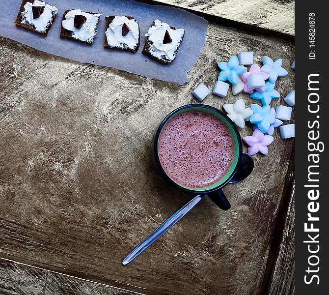 Cocoa, chocolate and colored sweets on the table. Cocoa, chocolate and colored sweets on the table