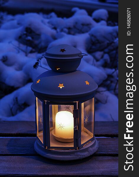 Lantern on snow. Winter garden