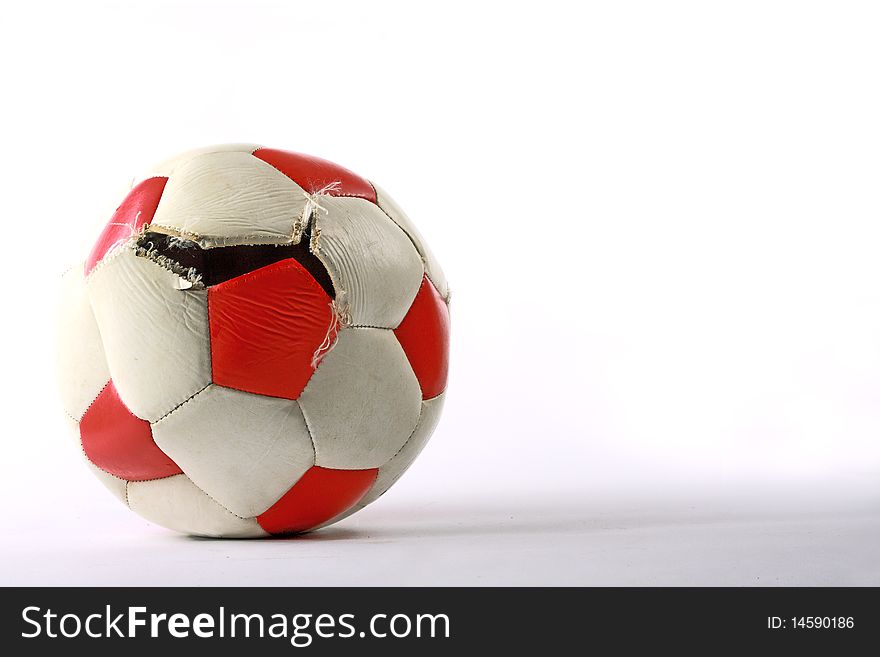 Torn red and white soccer ball. Torn red and white soccer ball