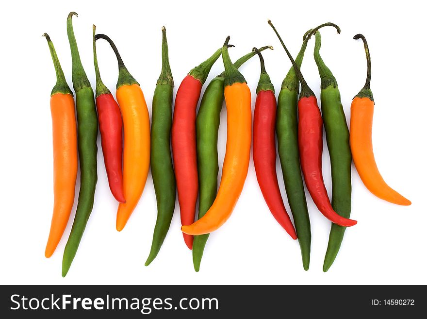 Mixed coloured chilli peppers on a white background