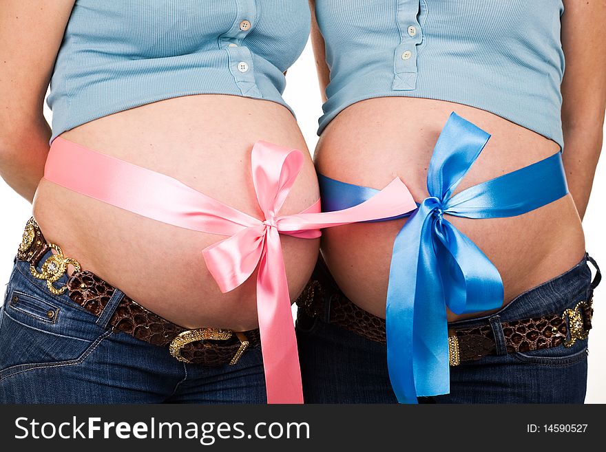 Two pregnant women with bowknots on their belly. Two pregnant women with bowknots on their belly