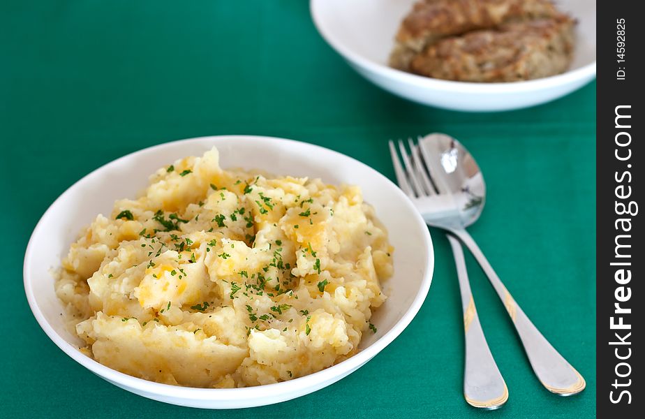 Serving of tatties and neeps with haggis behind. Serving of tatties and neeps with haggis behind