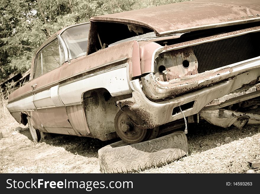 An old abandoned car in the woods.